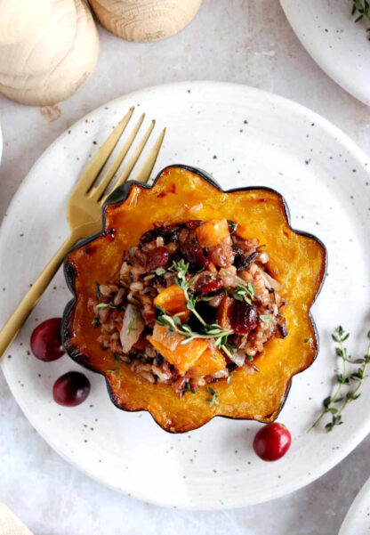 Wild rice stuffed acorn squash is an easy, healthy and nutritious vegetarian dish featuring roasted acorn squash halves filled with wild rice, mushrooms and cranberries.