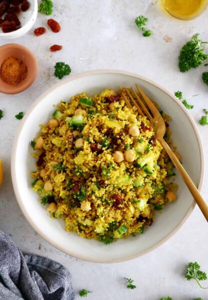 This Moroccan-inspired chickpea couscous salad consists in a delicious couscous flavored with ras el hanout, golden raisins, chickpeas and fresh herbs.