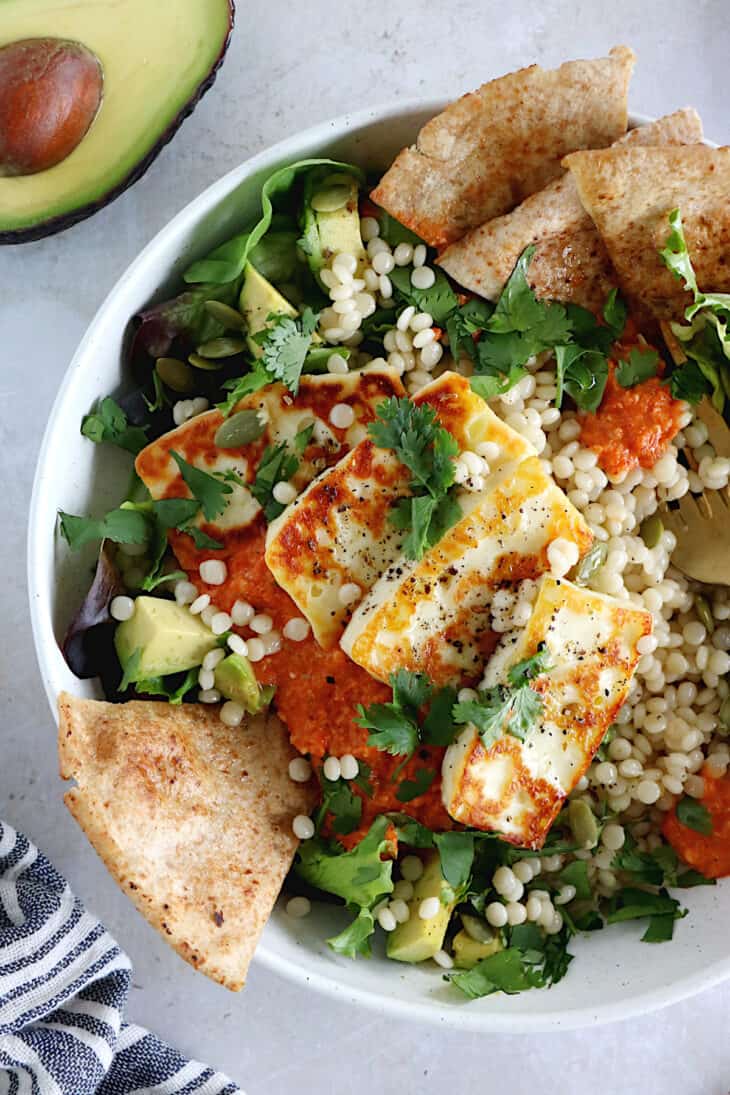 Le salade bowl de couscous perlé, halloumi et sauce romesco, c'est un plat complet, nourrissant et riche en saveurs.