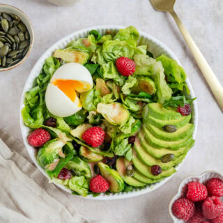 Simple et délicieuse salade d'avocat, framboises et oeufs mollets avec une vinaigrette de framboises.