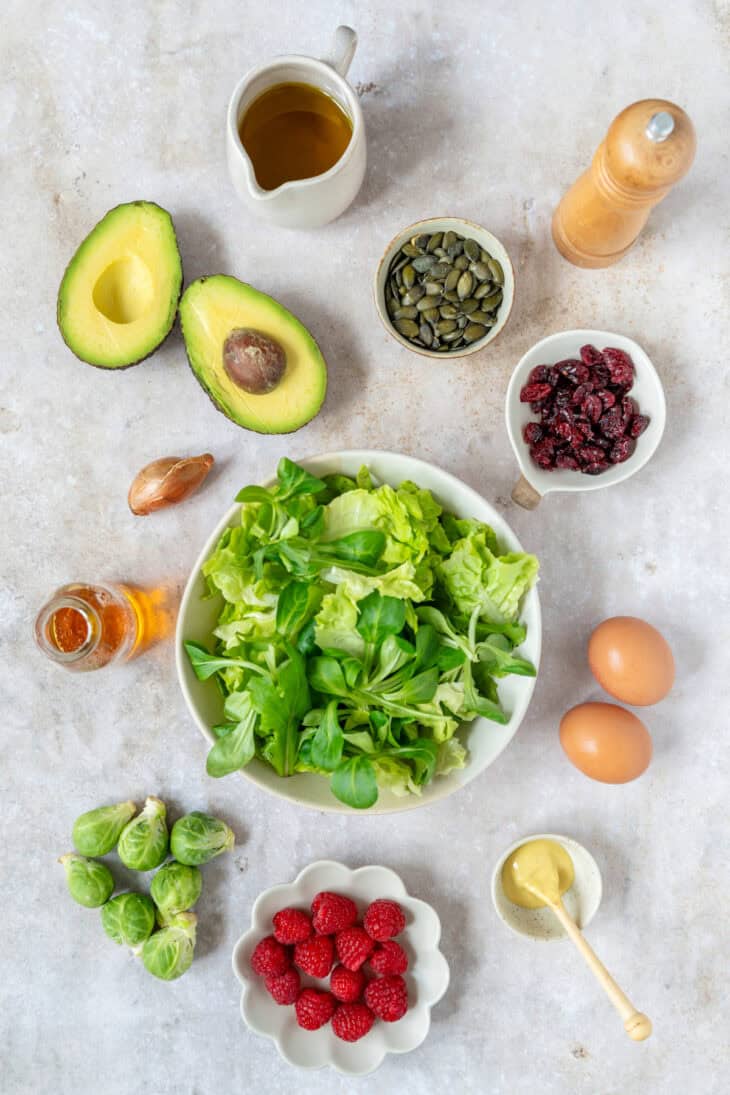 Simple et délicieuse salade d'avocat, framboises et oeufs mollets avec une vinaigrette de framboises.