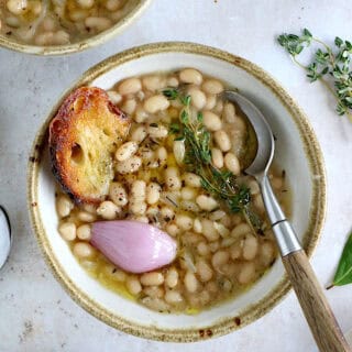 These brothy white beans infused with fresh herbs make a cozy meal packed with flavors. They're easy to make (no soaking time needed).