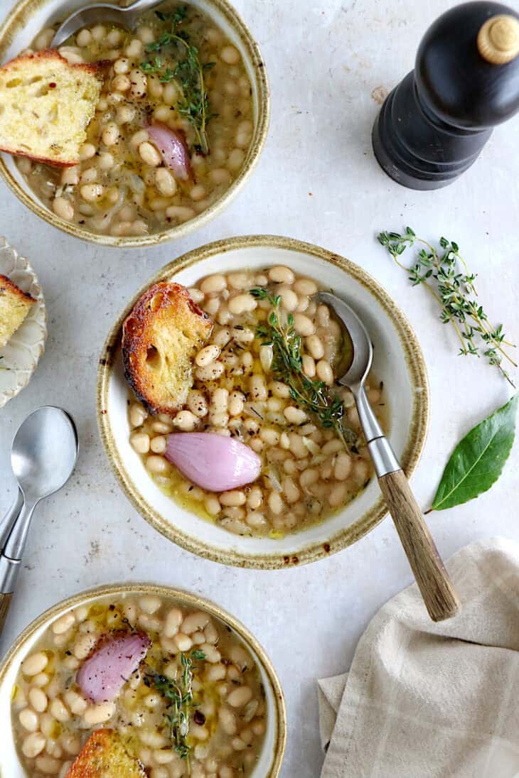 These brothy white beans infused with fresh herbs make a cozy meal packed with flavors. They're easy to make (no soaking time needed).