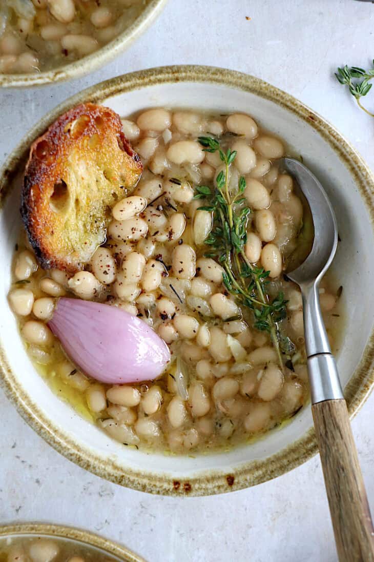 These brothy white beans infused with fresh herbs make a cozy meal packed with flavors. They're easy to make (no soaking time needed).