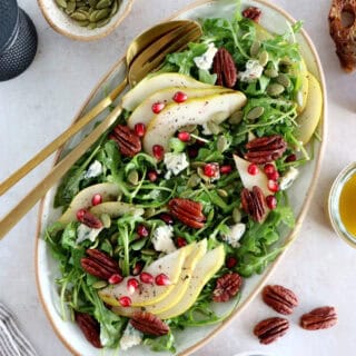 This simple arugula pear salad with blue cheese and pecans is light, fruity, crunchy, and tossed in a simple maple Dijon vinaigrette.