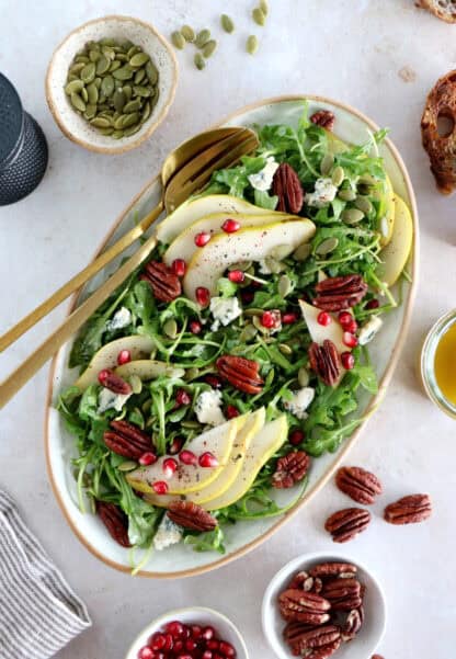 This simple arugula pear salad with blue cheese and pecans is light, fruity, crunchy, and tossed in a simple maple Dijon vinaigrette.