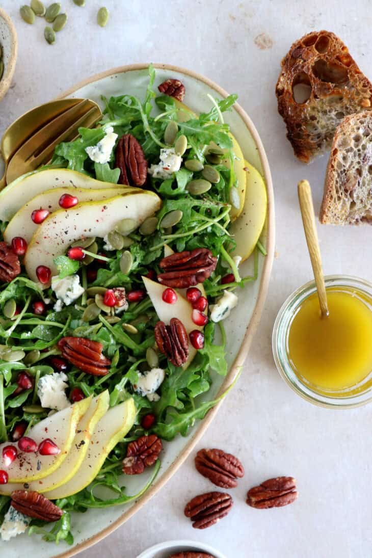 This simple arugula pear salad with blue cheese and pecans is light, fruity, crunchy, and tossed in a simple maple Dijon vinaigrette.